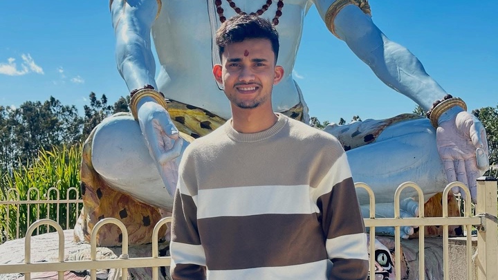 a young man standing near an idol