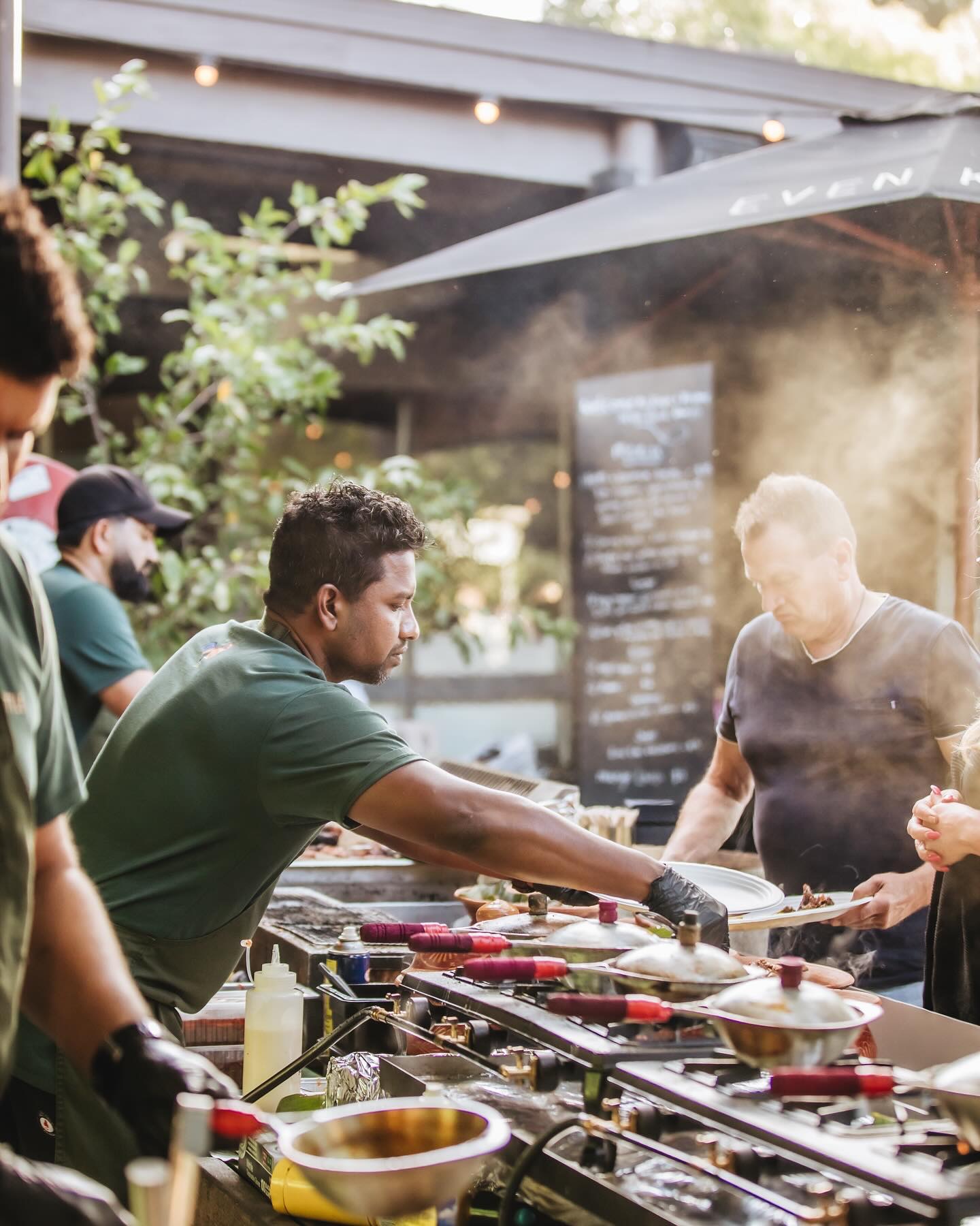 man cooking with people around him