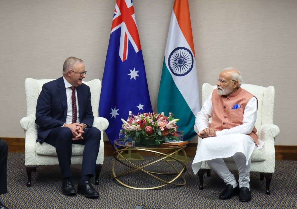 man in suit and man in traditional dress sitting