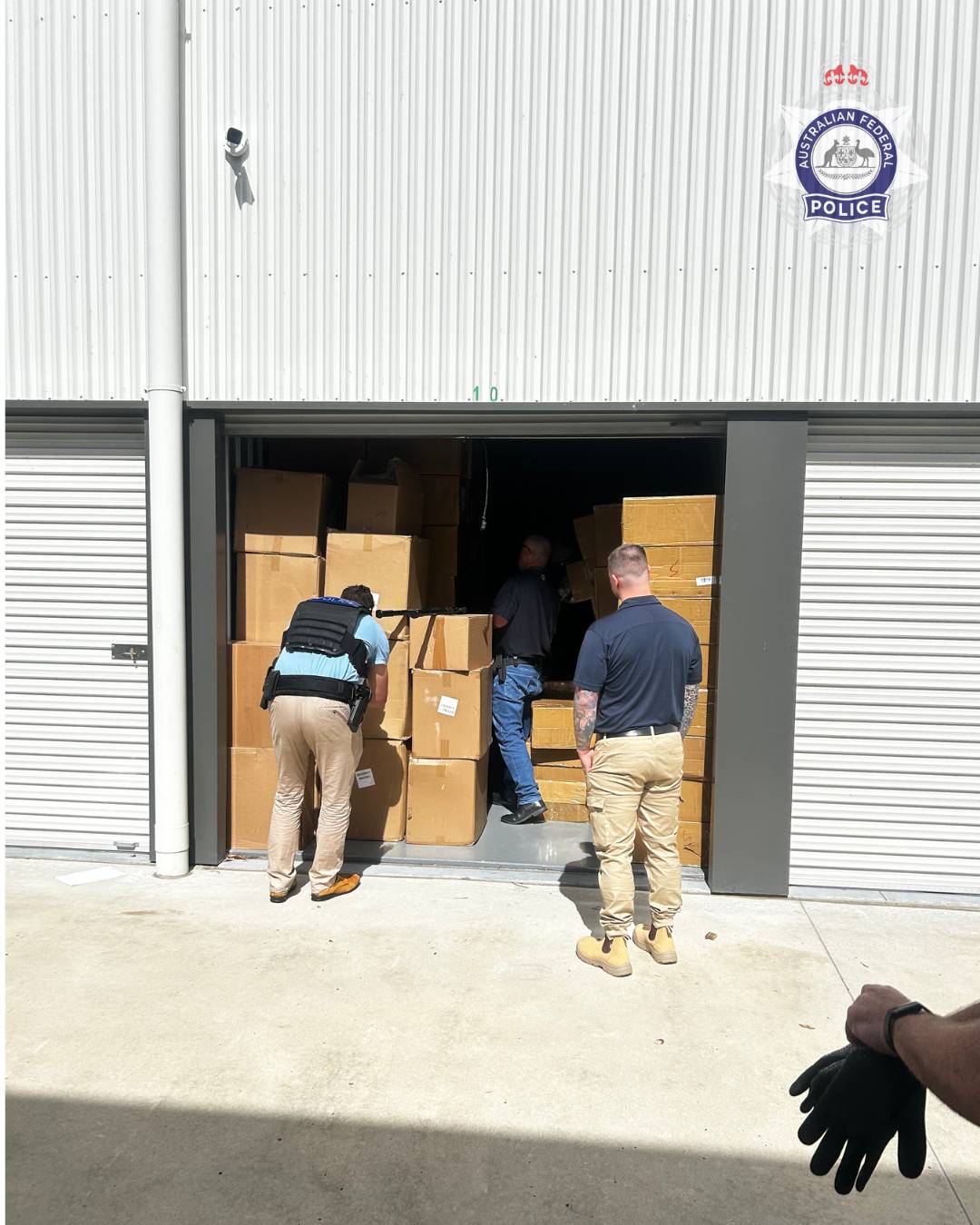 men in uniform checking cardboad boxes