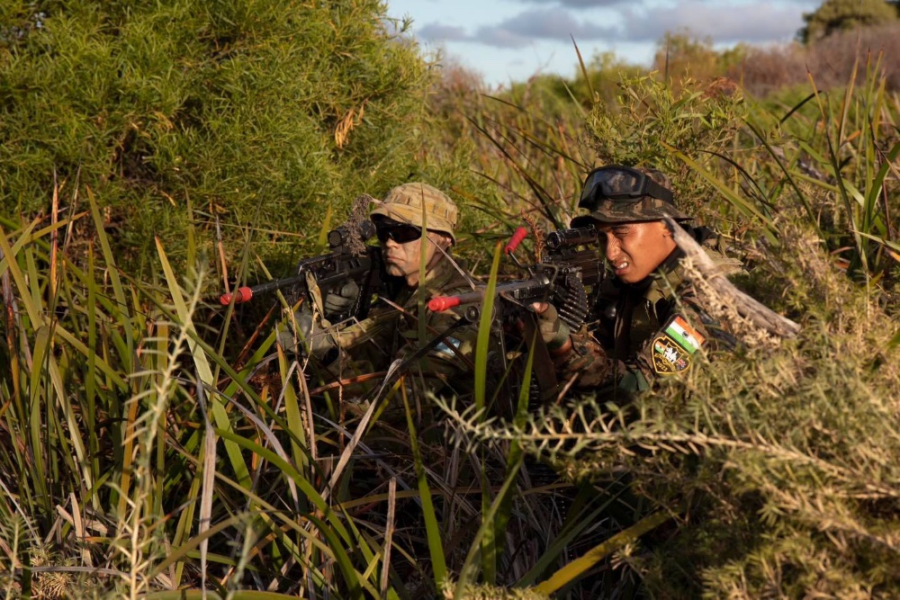 two men in army unifrom holding guns