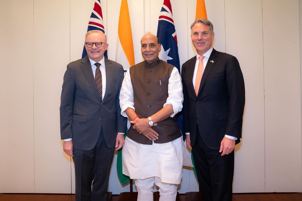 Three men standing in front of flags