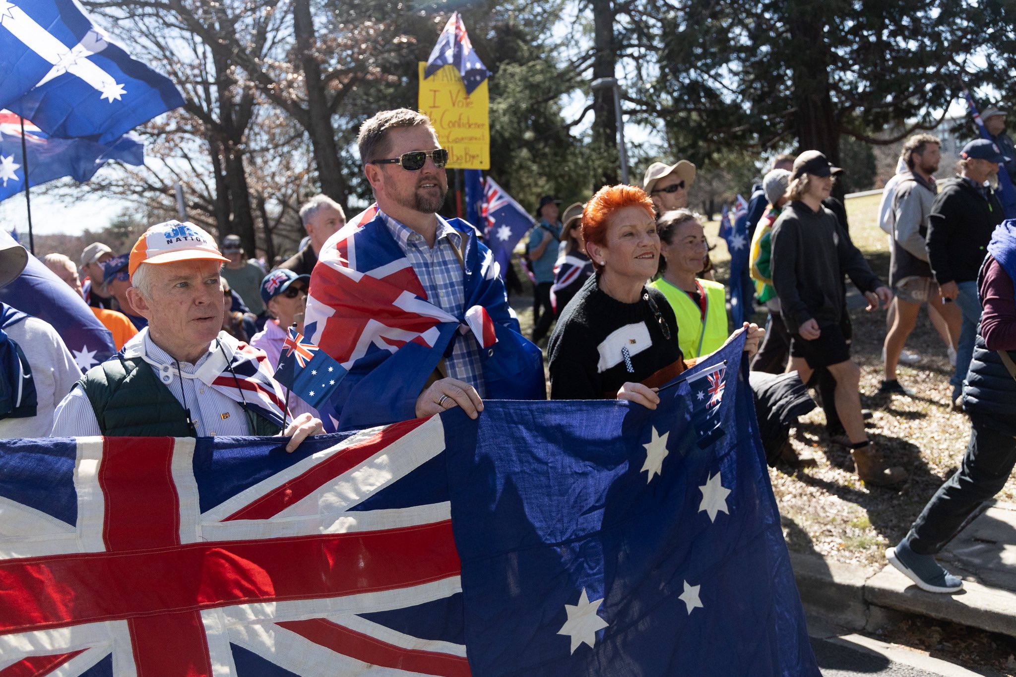 men and women marching with Australia's national flag.